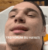a close up of a man 's face with the words " yaşiyorum bu hayati " on the bottom right