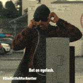 a man wearing sunglasses and a beanie is talking on a pay phone and the caption says bat an eyelash