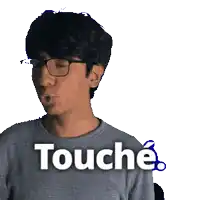 a man wearing glasses and a grey shirt with the word touche written on it
