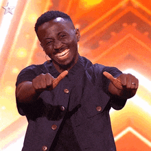 a man in a black jacket is pointing and smiling