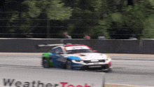 a race car is on a track with a sign that says weathertech