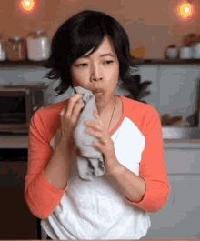 a woman is holding a towel over her mouth