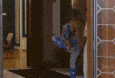 a woman in blue boots is standing in a doorway with her legs crossed .