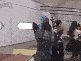 a group of people are standing in a room with a dog standing in the foreground