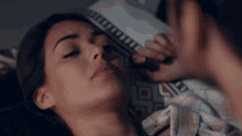 a woman laying on a bed with a man applying makeup to her face