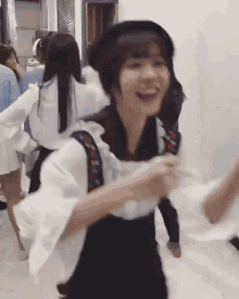 a woman wearing a black hat and a white shirt is dancing in a room