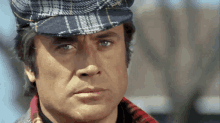 a close up of a man wearing a plaid hat and a plaid shirt