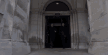 two men are walking into a building with a sign on the door that says ' united states army '