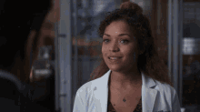 a woman in a lab coat with a name tag that says ' sarah ' on it
