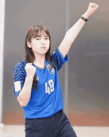 a girl wearing a blue jersey with the number 48