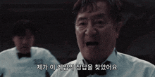 a man in a white shirt and bow tie is speaking in korean