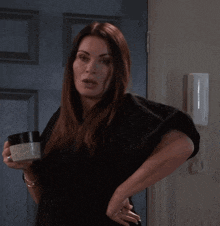 a woman in a black shirt is holding a container that says ' moisturizing ' on it