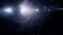 a woman is dancing in a dark room in front of a galaxy .