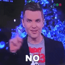 a man in a suit is pointing at the camera with the word no on his face