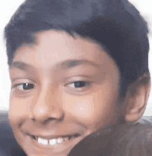 a close up of a boy 's face smiling