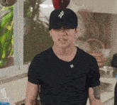 a man wearing a black shirt and a black hat