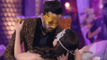a man and a woman wearing masks are hugging