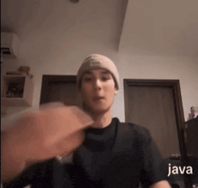 a man wearing a beanie and a black t-shirt with the word java on the bottom