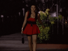a woman in a red dress walking down a street