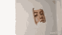 a painting of a woman 's face is being painted on a white surface .