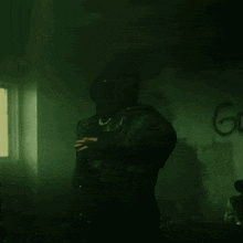 a man in a mask is dancing in front of a wall that says go