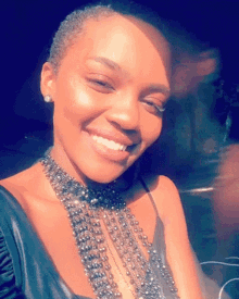 a woman wearing a choker necklace is smiling for the camera