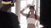 a woman in a bunny costume is standing in front of a window with the word madman on the bottom right