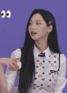 a girl with long black hair is wearing a white shirt and a white vest