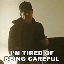 a man in a black jacket and hat says " i 'm tired of being careful "