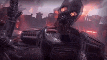 a robot with red eyes is standing in front of a burning city .