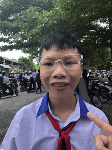 a young boy wearing glasses and a red tie is pointing at something