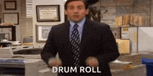 a man in a suit and tie is dancing in an office with the words `` drum roll '' .