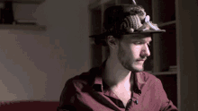 a man with a beard wearing a hat with feathers on top