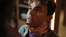 a woman is holding a man 's neck and looking at him .
