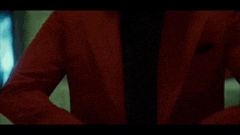 a man in a red jacket and black tie