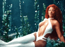 a woman with red hair is laying in the water wearing a white bodysuit and white stockings
