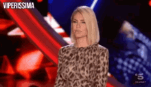 a woman in a leopard print dress is standing in front of a red background .