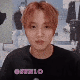 a man with red hair is wearing a black shirt with the word osunio on it