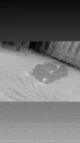 a black and white photo of a car driving in the snow .