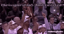 a man is holding a trophy in front of a crowd .