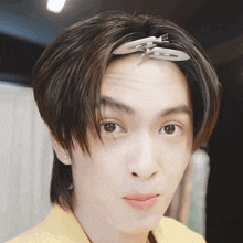 a close up of a person 's face with a hair clip on their head