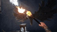 a person holding a torch in front of an owl with wings