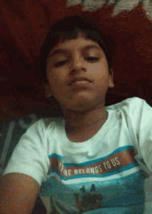 a young boy wearing a vibe belongs to us t-shirt