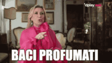 a woman in a pink dress says " baci profumi "
