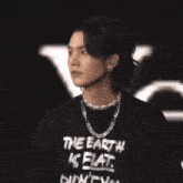 a young man wearing a black shirt that says the earth is fat