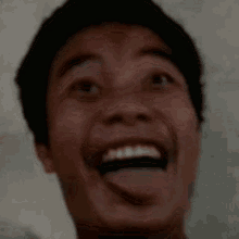 a man is sticking his tongue out and smiling .