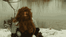 a man with long red hair and a beard is in the snow
