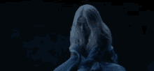 a woman with long white hair is holding a blue cloth