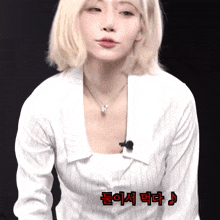 a woman wearing a white striped shirt has korean writing on the bottom