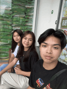 a boy and two girls sit in front of a sign that says hdb